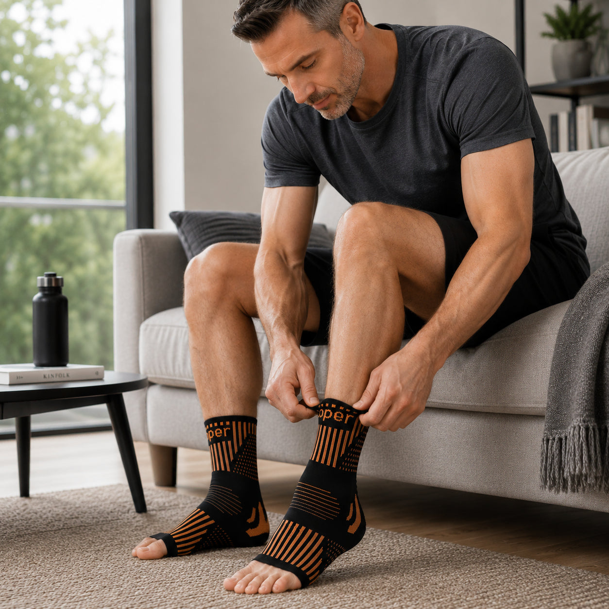 Un homme enfile une chevillère de compression à la maison.