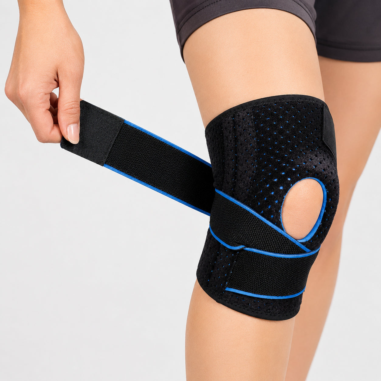 Genouillère avec doubles stabilisateurs latéraux, ouverture pour la rotule et sangle de compression réglable pour la stabilité et le soulagement.