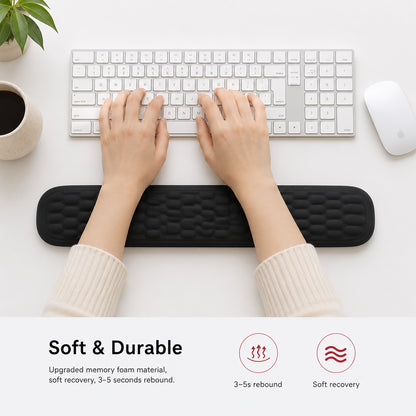 Une personne utilise un repose-poignet ergonomique en mousse à mémoire de forme au clavier pour plus de confort et de soulagement.
