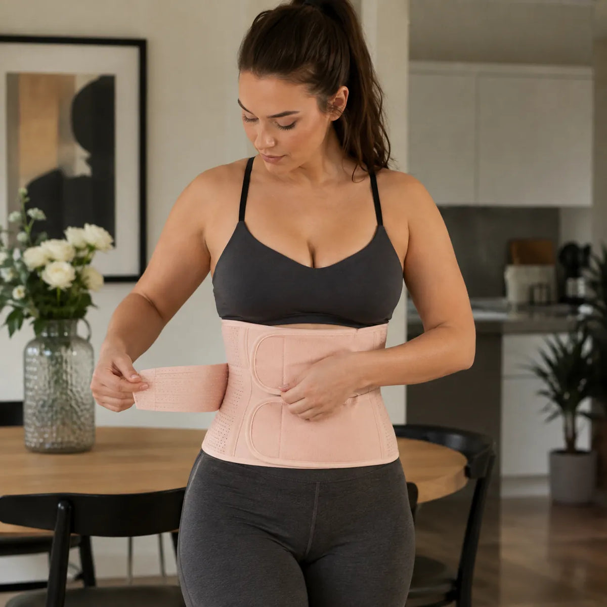 La femme ajuste un tailleur beige avec des doubles bretelles autour de la taille.