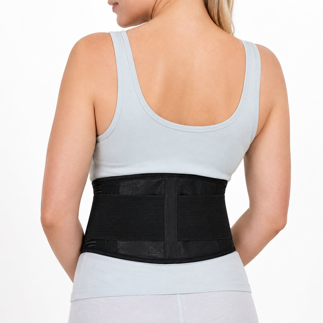 Une femme porte une ceinture de soutien lombaire réglable pour la stabilité et le soutien du bas du dos.