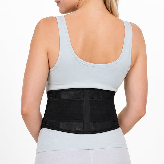 Une femme porte une ceinture de soutien lombaire réglable pour la stabilité et le soutien du bas du dos.