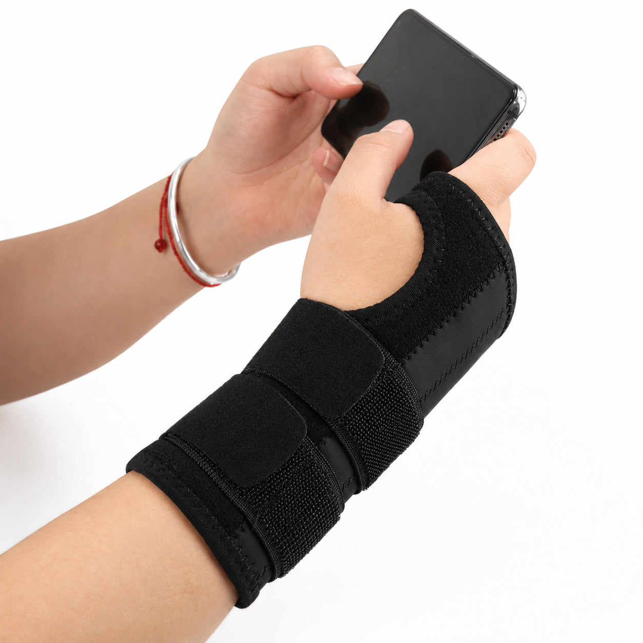Une personne utilise un bandage de poignet stable en utilisant son téléphone.